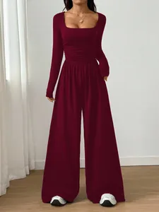 Full length fashion shot of a burgundy square neck long sleeve wide leg jumpsuit