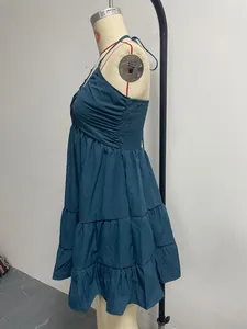 Side view of blue halter dress with tiered ruffles and pleated bodice on mannequin