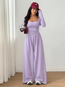 Detail view of a stylish purple long-sleeve square-neck wide-leg jumpsuit on model