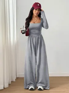 Full length view of a grey long-sleeved square neck wide leg jumpsuit on a model