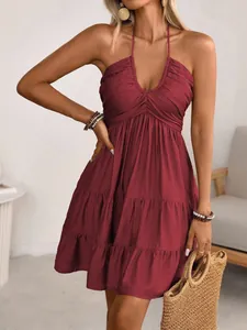 Close-up of wine red halter V-neck dress with pleated bodice and tiered ruffle skirt.