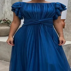 Close-up detail of an elegant blue pleated floor-length dress with a stylish waist twist