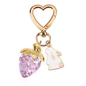Detail of translucent purple strawberry and white rabbit charms on heart keychain