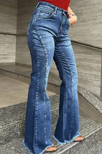 Detailansicht der Seitennähte und der ausgefransten Säume von blauen Schlagjeans