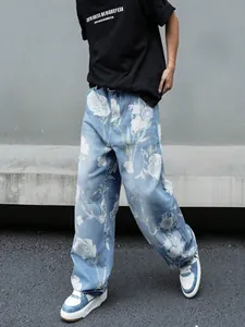 Dettaglio dei jeans larghi da uomo con stampe floreali di rose bianche