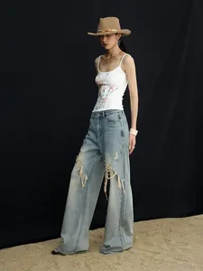 Jean large à revers pour femme, style high-street avec détails déchirés et usés.