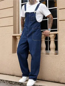 Full-length detail of men's dark blue denim overalls featuring a front zipper and pockets