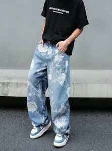 Vista dettagliata dei jeans da uomo azzurri con stampa a rose bianche in taglio street ampio