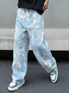 Primo piano di jeans da uomo larghi a gamba dritta con stampa floreale bianca.