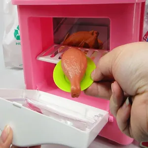 Close-up detail of a pink simulation toy microwave oven with a miniature chicken leg
