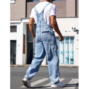 Men's light blue acid wash denim bib overalls with adjustable straps in a street setting