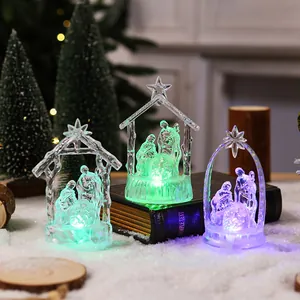 Close-up of three crystal-style LED nativity scene ornaments with colorful lights