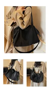 Large black canvas travel bag on model, featuring spacious interior and retro chic design.