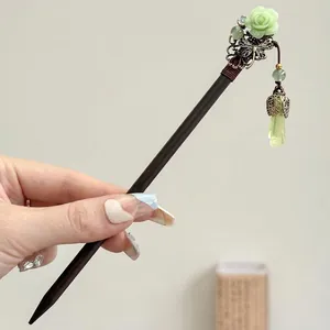 Detail view of an elegant vintage Chinese tassel hairpin with a green rose and butterfly.