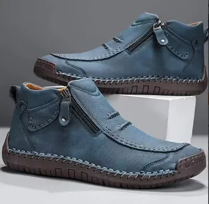 Detalle de botas altas de cuero azul hechas a mano con cremallera lateral y pespuntes.