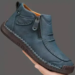 Detalle de botines Chelsea de cuero azul para hombre con costuras hechas a mano.