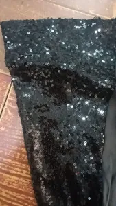 Vista ravvicinata del tessuto con paillettes nere lucide per abbigliamento da palco anni '70
