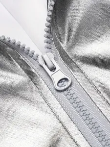 Primer plano de la cremallera y el tejido metálico plateado brillante de la chaqueta