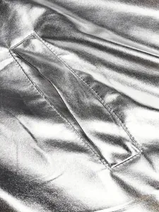Detalle de la tela metálica plateada y el bolsillo de la chaqueta de fiesta disco de los 70