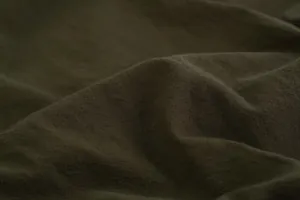 Close-up detail of dark olive breathable cotton linen fabric with natural folds