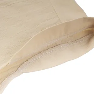 Dettaglio della cucitura interna pulita su una camicia medievale in lino color beige