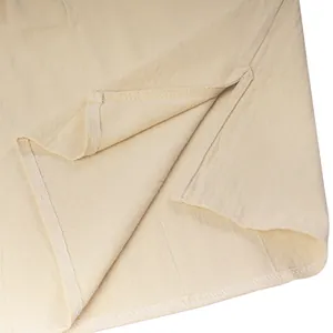 Dettaglio camicia medievale senza maniche beige con spacco laterale e trama del tessuto