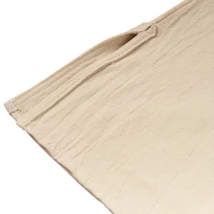 Primo piano del dettaglio spacco laterale su camicia rinascimentale beige in lino