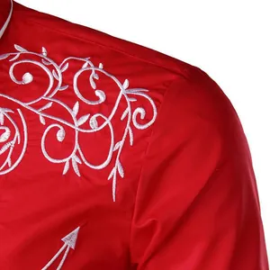 Detailed macro view of white vine embroidery on a vibrant red Western cowboy shirt