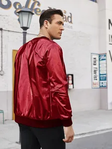 Vista posterior de hombre con chaqueta bomber roja metalizada brillante en entorno urbano