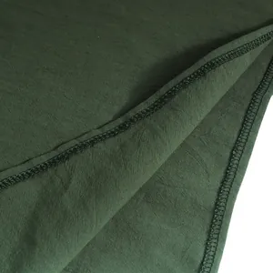 Dettaglio del tessuto verde scuro e delle cuciture nere di una camicia vichinga medievale