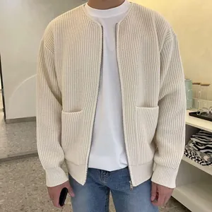 Close-up of a men's cream-colored knit cardigan with zipper and pocket details