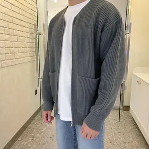 Close-up of a men's gray oversized ribbed knit cardigan with zipper and front pockets