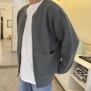 Detailed view of a men's gray oversized knit zip-up cardigan with pocket accents