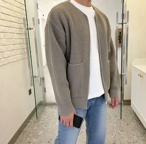 Detail of a men's loose-fit ribbed knitted cardigan in olive grey with front pockets
