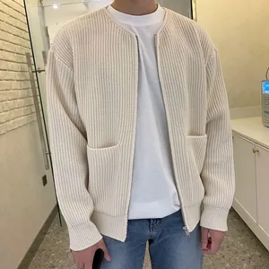Detail view of men's loose beige knit cardigan with zipper and front pockets