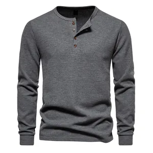 Detailed view of the four-button placket and waffle-knit texture of a grey Henley shirt.