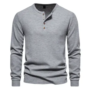 Close-up of a grey waffle-knit henley shirt with four wooden-style buttons for men.