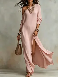 Vue détaillée d'une élégante robe longue plissée rose avec fente haute et manches.
