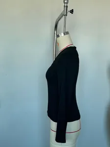 Side view detail of a slim-fit black V-neck long-sleeve top on a mannequin.