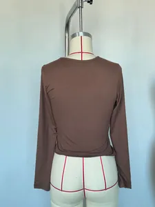 Detailed back view of a slim fit brown milk silk long-sleeve top on a mannequin stand