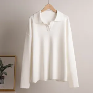 Elegant detail view of a white knit polo sweater featuring a V-neckline and long sleeves