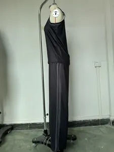 Vista laterale di un top nero senza maniche e pantaloni larghi con strisce laterali.