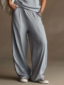 Dettaglio dei pantaloni larghi grigio-blu da donna con strisce laterali sportive