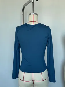 Back view of a slim-fit teal long-sleeved top on a mannequin showing fabric texture