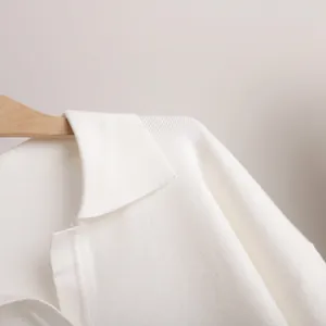Detailed view of a white knitted Polo collar pullover showing fine fabric texture and ribbing