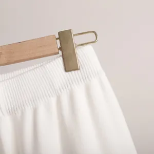 Detailed macro view showing the texture of a white ribbed knit waistband on casual pants