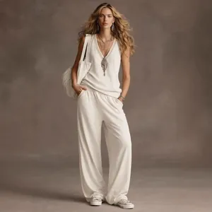Elegante completo bianco con top scollo a V senza maniche e pantaloni a gamba larga.