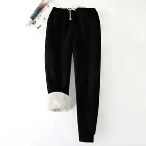Detalle de pantalones de chándal negros de invierno para mujer con forro de felpa blanca