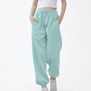 Vista frontal completa de pantalones deportivos holgados verde menta para niños con cordón