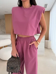 Detail shot of mauve two-piece set featuring padded shoulder top and high-waisted pants